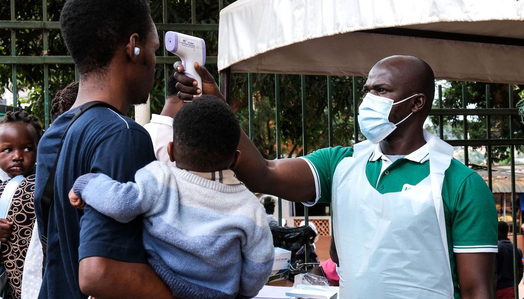 A health official uses a thermometer to screen people in front of Kibuli Muslim Hospital in Kampala, Uganda, on May 16, 2026. (AP)