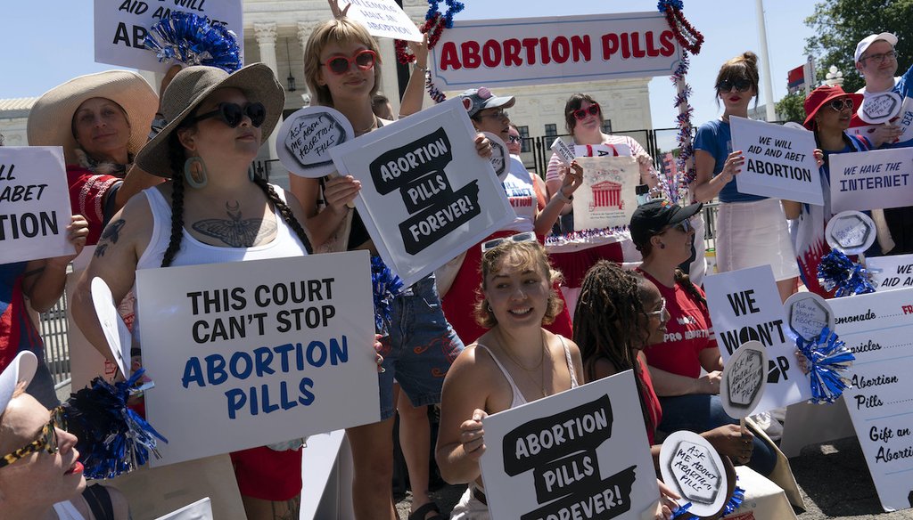 Abortion-rights activists setup an abortion pills educational booth as they protest outside the Supreme Court in Washington on July 4, 2022 (AP)