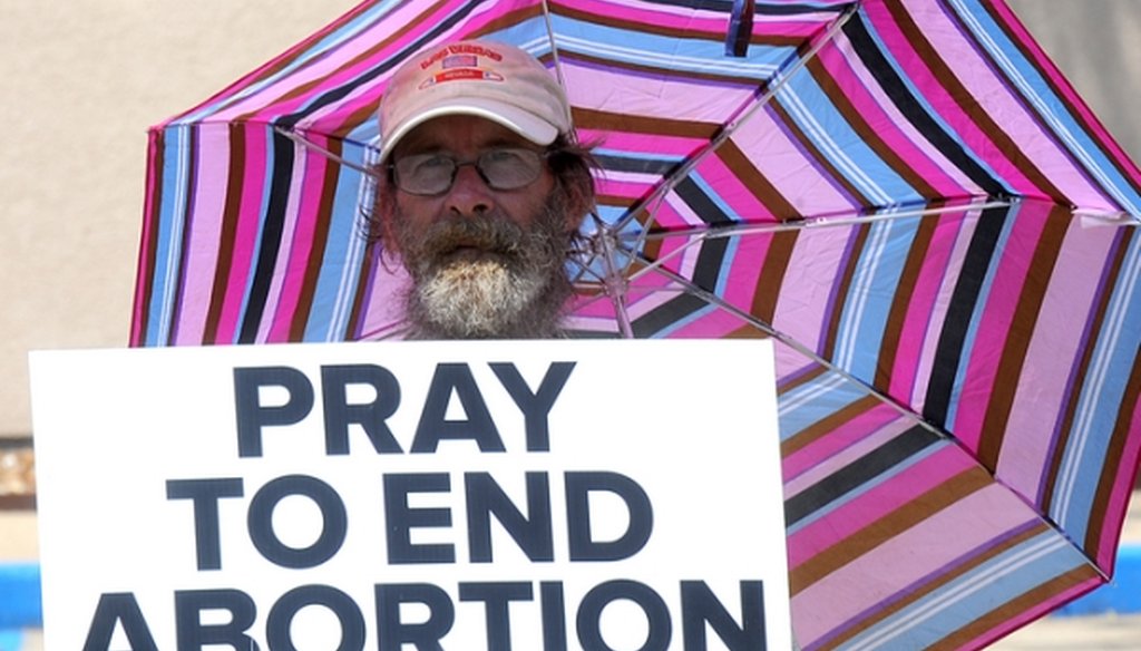 A protester holds a sign in front of Planned Parenthood of Kansas and Mid-Missouri in Columbia, Mo., on July 28, 2015. (Don Shrubshell/Columbia Daily Tribune via AP)
