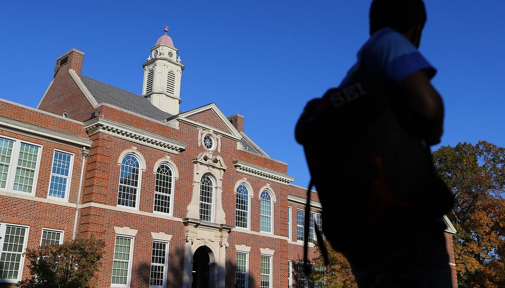 A student walks by Druid Hills High School in November. The school is in a neighborhood considering annexation into Atlanta. Photo by Curtis Compton / AJC.