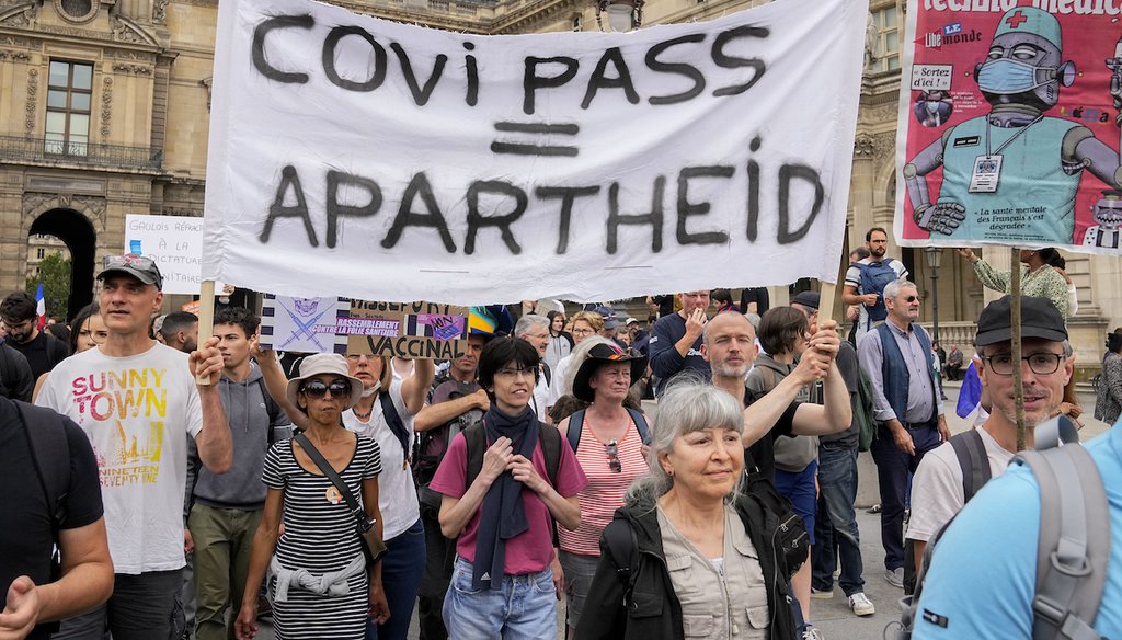 Anti-vaccine protesters march with a banner during a rally in Paris, July 17, 2021. (AP)