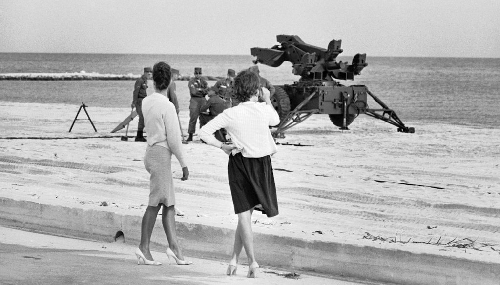 Two Key West, Fla., girls focus their attentions on U.S. Army soldiers setting up anti-aircraft missile launchers on a beach in Key West, Florida on Oct. 26, 1962, during the Cuban Missile Crisis. (AP)