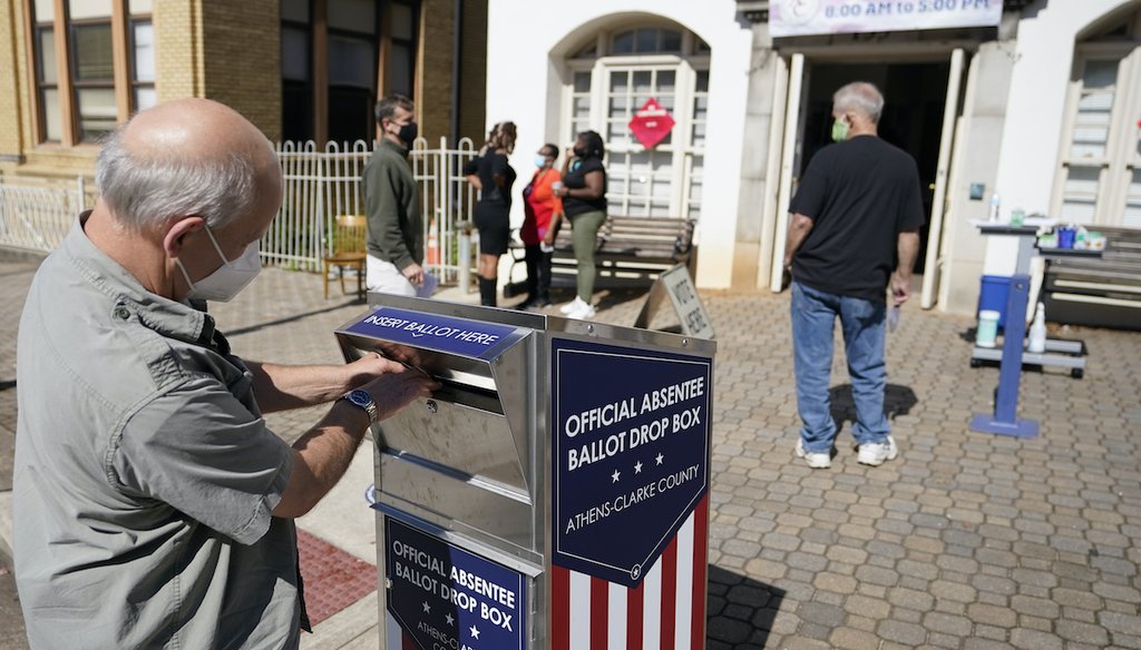 In this Oct. 19, 2020 file photo, a voter submits a ballot in an official drop box during early voting in Athens, Ga. (AP)