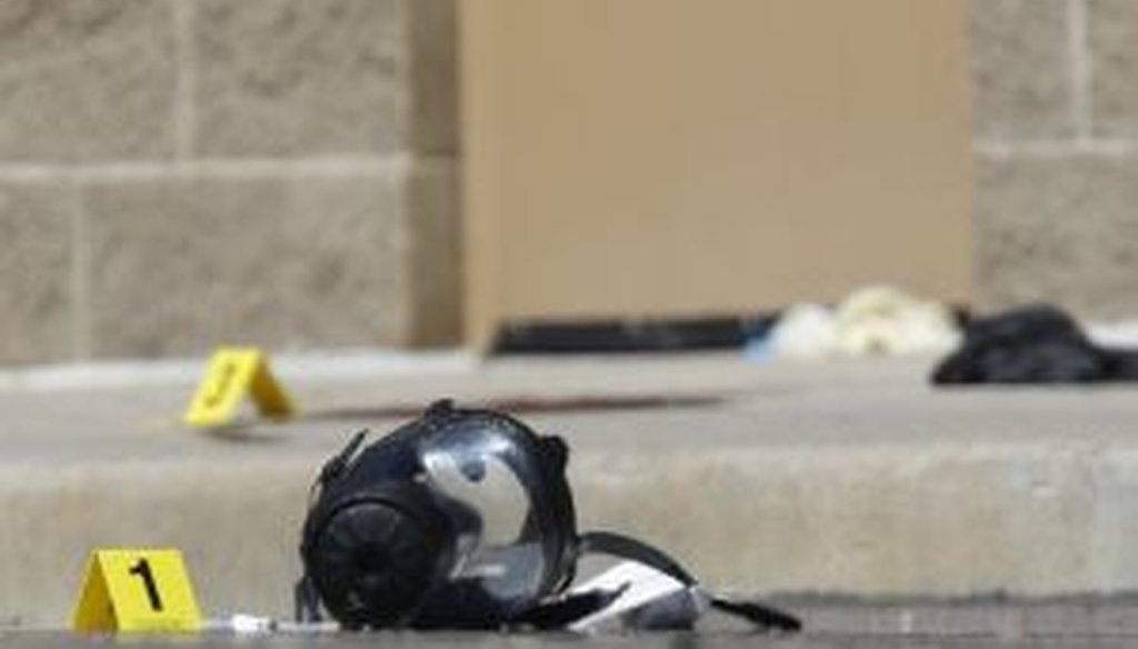 Yellow markers sit next to evidence, including a gas mask, as police investigate the scene outside the Century 16 movie theater east of the Aurora Mall in Aurora, Colo., the site of one of the deadliest mass shootings in recent U.S. history.