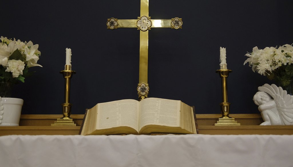 Una cruz y una Biblia abierta en el altar de la Iglesia Metodista Unida Turning Point en Trenton, Nueva Jersey, el 13 de mayo de 2024.