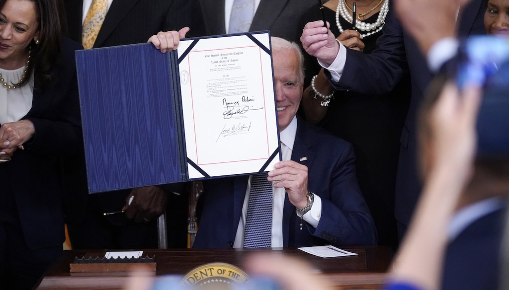 President Joe Biden holds the Juneteenth National Independence Day Act after signing it in the East Room of the White House. (AP Photo/Evan Vucci)
