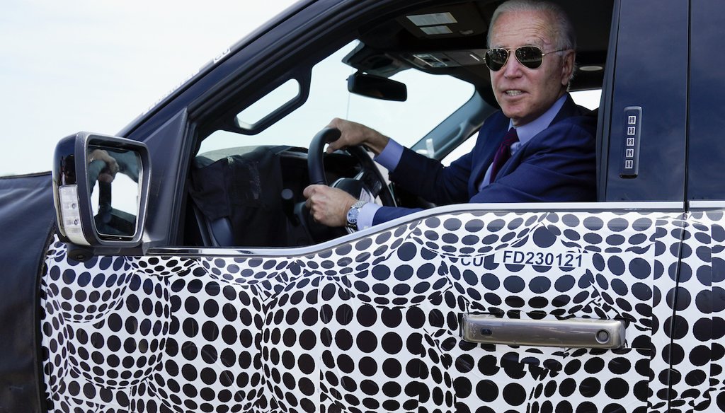 President Joe Biden stops to talk to the media as he drives an electric-powered Ford F-150 truck. Shifting to electric cars and trucks is key to reaching Biden’s carbon reduction goals. (AP Photo/Evan Vucci)