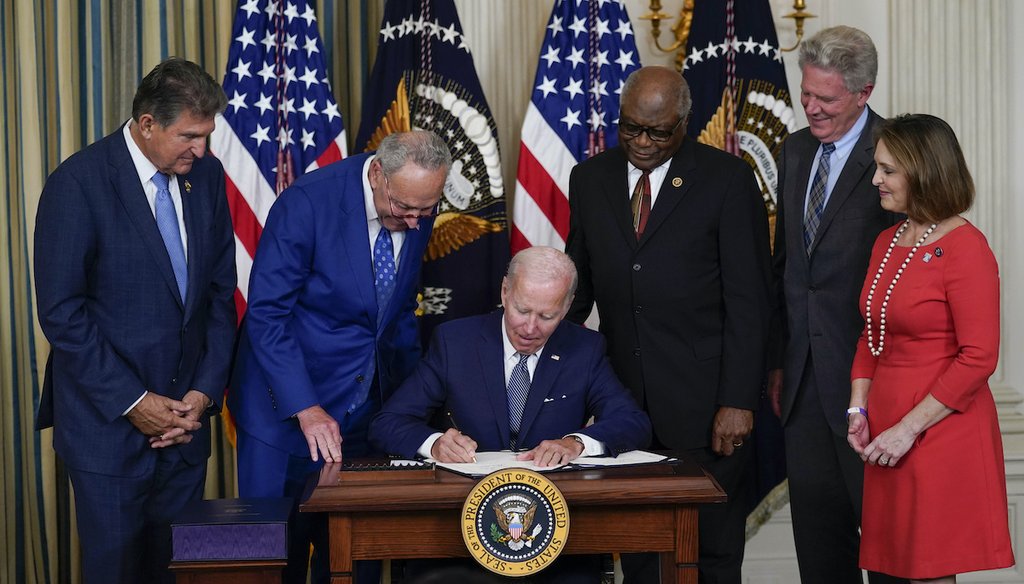 President Joe Biden signs the Democrats' landmark climate change and health care bill in the State Dining Room of the White House in Washington, Tuesday, Aug. 16, 2022, as Democratic lawmakers watch. (AP)