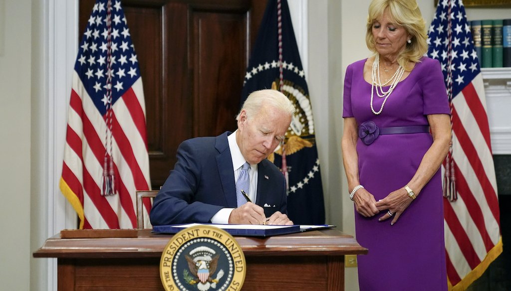President Joe Biden signs into law the Bipartisan Safer Communities Act gun safety bill, June 25, 2022. First lady Jill Biden looks on. (AP)