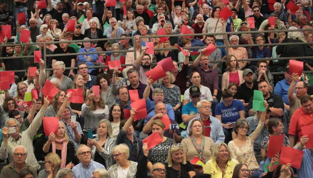 Voters at a town hall meeting in Iowa raised red sheets of paper when they disagreed with Rep. Rod Blum (R-Iowa). (Getty Images)
