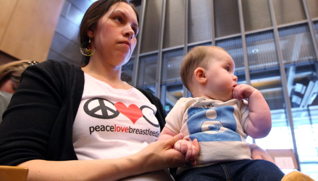 A woman holds her daughter after testifying in front of the Seattle City Council, April 9, 2012 (AP).