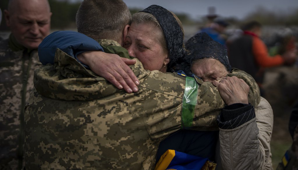 Irina Tromsa, 55, is comforted by comrades of her son Bogdan, 24, a Ukrainian paratrooper killed during fighting against Russian troops, during his funeral at the cemetery in Bucha, in the outskirts of Kyiv, on Saturday, April 23, 2022. (AP)