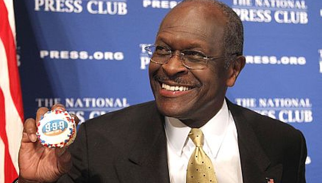 Republican presidential candidate Herman Cain shows off a 9-9-9 tax plan muffin Oct. 31