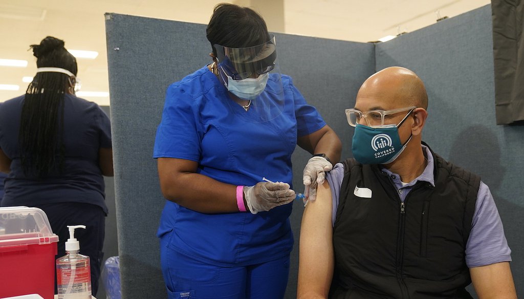 Licensed vocational nurse LeShay Brown, middle, inoculates Dr. Mark Ghaly, Secretary, California Health and Human Services, right, at the Baldwin Hills Crenshaw Plaza in Los Angeles Thursday, March 11, 2021. (AP)
