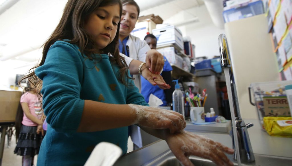 Jana Tinoco Gutierrez, a second grader at Ethel Phillips Elementary School in Sacramento, practices washing her hands as vocational nursing student Soledad Lupian watches in March 2020. (AP Photo/Rich Pedroncelli)