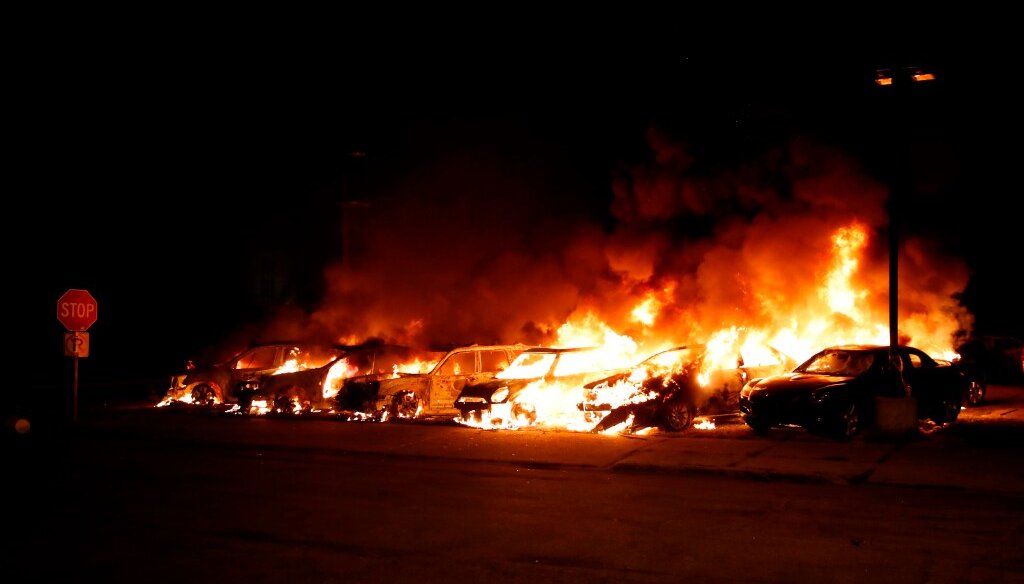 Cars set ablaze amid violent protests burn at the Car Source in Kenosha on Aug. 24, 2020. (Photo by KAMIL KRZACZYNSKI / AFP)