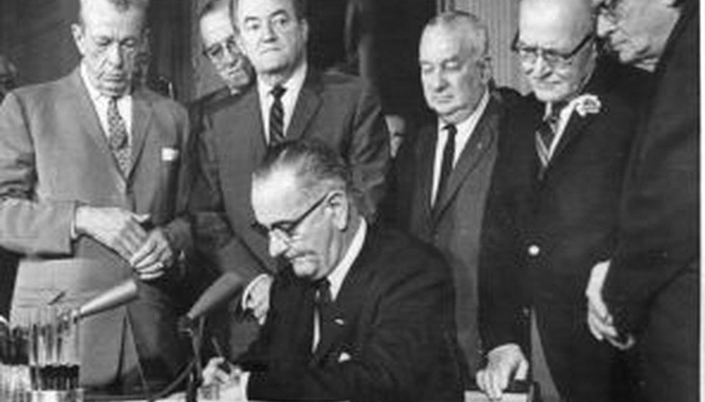 President Lyndon Johnson signs the Civil Rights Act. Also pictured are Sen. Everett Dirksen (left) and Reps. Charles Halleck and William McCulloch, all Republicans. 