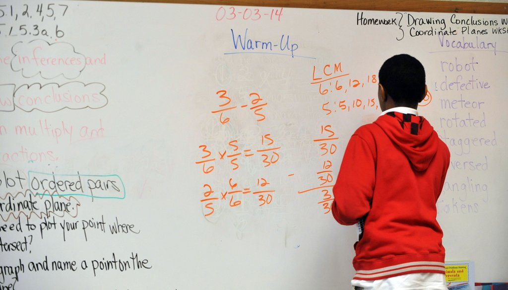 Fifth-grade student Tracey Bridges works a problem on the board at Venetian Hills Elementary School Monday, March 3, 2014. KENT D. JOHNSON / KDJOHNSON@AJC.COM