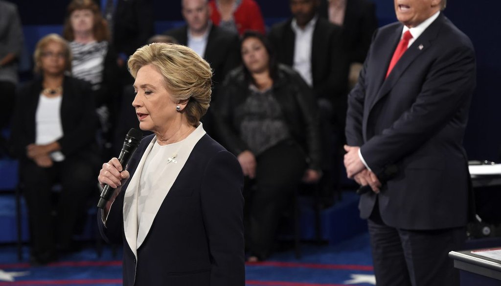 Democratic presidential nominee Hillary Clinton, left, talks as Republican presidential nominee Donald Trump watches her during the second presidential debate at Washington University in St. Louis, Sunday, Oct. 9, 2016. (Saul Loeb/Pool via AP)