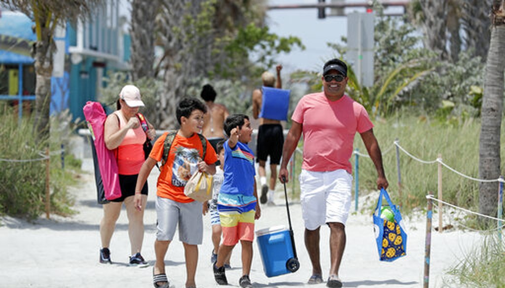 A family walks through an entrance to Cocoa Beach, Fla., Thursday, April 23, 2020. (AP)