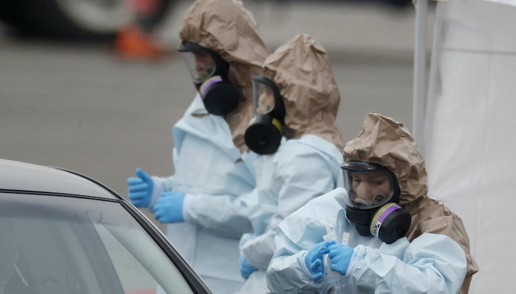 Colorado National Guard medical personnel at a drive-through coronavirus testing site outside the Denver Coliseum. (AP Photo/David Zalubowski)