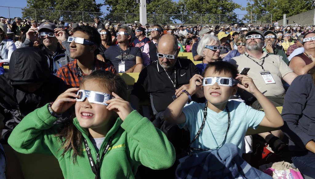 Crowd members wear protective glasses Aug. 21, 2017, as they watch the beginning of the solar eclipse from Salem, Ore. (AP)