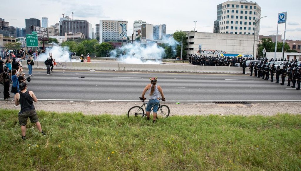 A protester watches as tear gas is used to clear out I35 during a protest in Austin, Texas on May 31. (Sergio Flores for AMERICAN-STATESMAN)