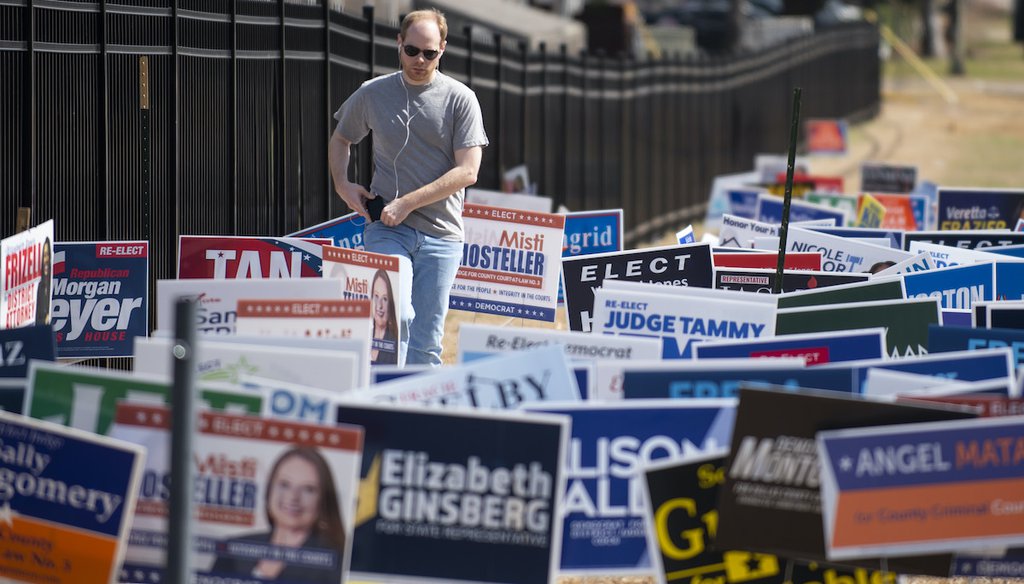 A voter walks through a field of signs alongside Park Lane to participate in the primary election at Our Redeemer Lutheran Church in Dallas, Texas on Tuesday, March 1, 2022. (AP)