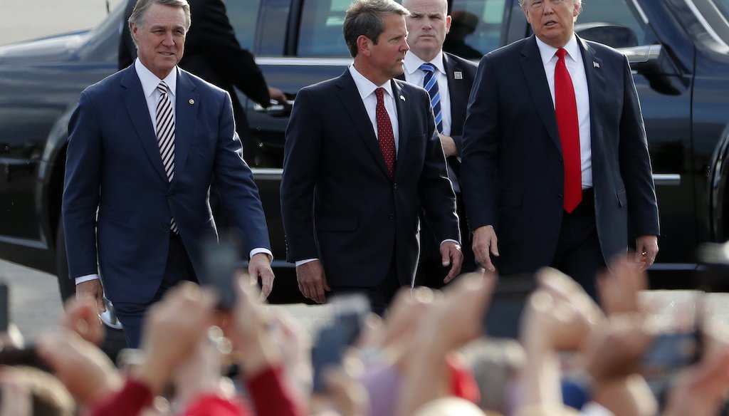 Brian Kemp, center, walks with President Donald Trump, right, and Sen. David Perdue as Trump arrives for a rally Nov. 4, 2018, in Macon, Ga. Perdue is challenging Kemp, the Georgia governor, for the 2022 GOP nomination for governor. (AP)