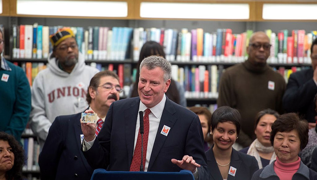 New York City Mayor Bill de Blasio holds a municipal identification card. (Courtesy: New York City Mayor's Office)