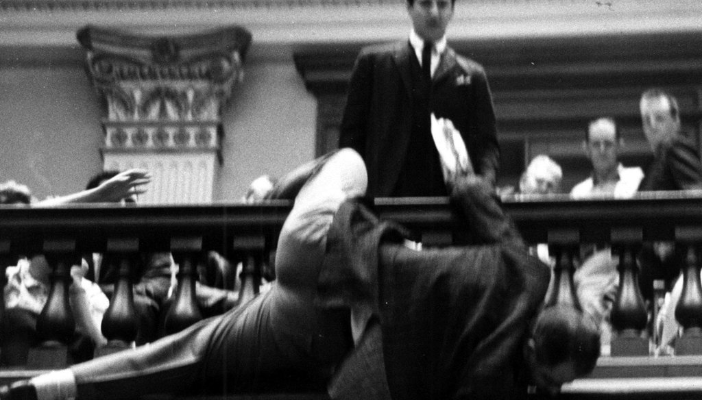 During a 1964 speech on re-apportionment, Rep. Denmark Groover, D-Macon, nearly fell over the state House railing trying to adjust the hands of the clock to keep it from reaching midnight. File photo by Joe McTyre / AJC