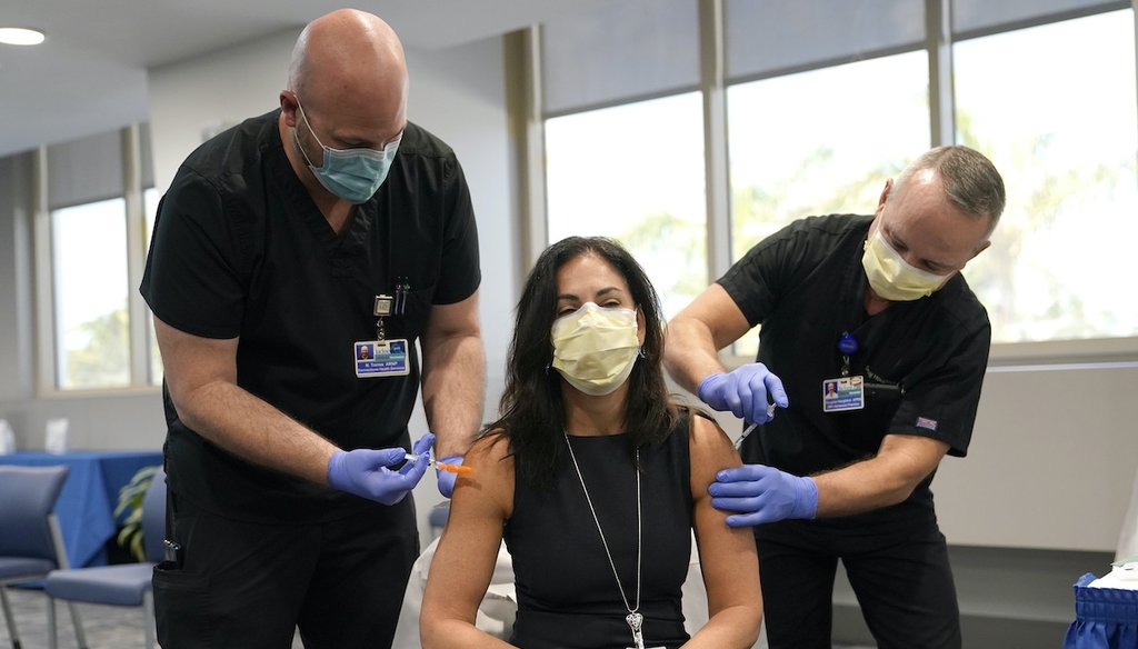 Dr. Lilian Abbo, center, receives a flu vaccine and a Pfizer COVID-19 booster shot at Jackson Memorial Hospital Tuesday, Oct. 5, 2021, in Miami. The Centers for Disease Control and Prevention says it is safe to get both vaccines at the same time. (AP)