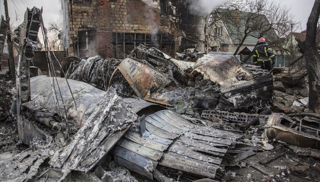 A Ukrainian firefighter walks between at fragments of a downed aircraft seen in in Kyiv, Ukraine, Friday, Feb. 25, 2022. (AP)