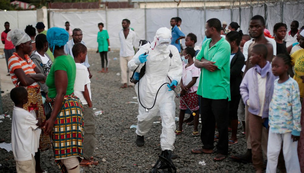 A medical worker sprays people being discharged from the Island Clinic Ebola treatment center in Monrovia, Liberia. (AP Photo/Jerome Delay)