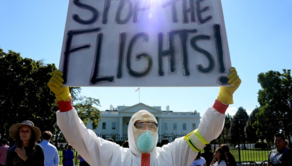 A protester stands outside the White House asking President Barack Obama to ban flights in an effort to stop Ebola on Oct. 17, 2014.