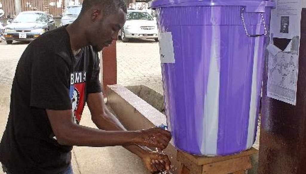 A man in Freetown, Sierra Leone, washes his hands with disinfectant to prevent Ebola infection before entering a hospital on July 15, 2014. An Ebola outbreak in Liberia and Sierra Leone is ongoing.