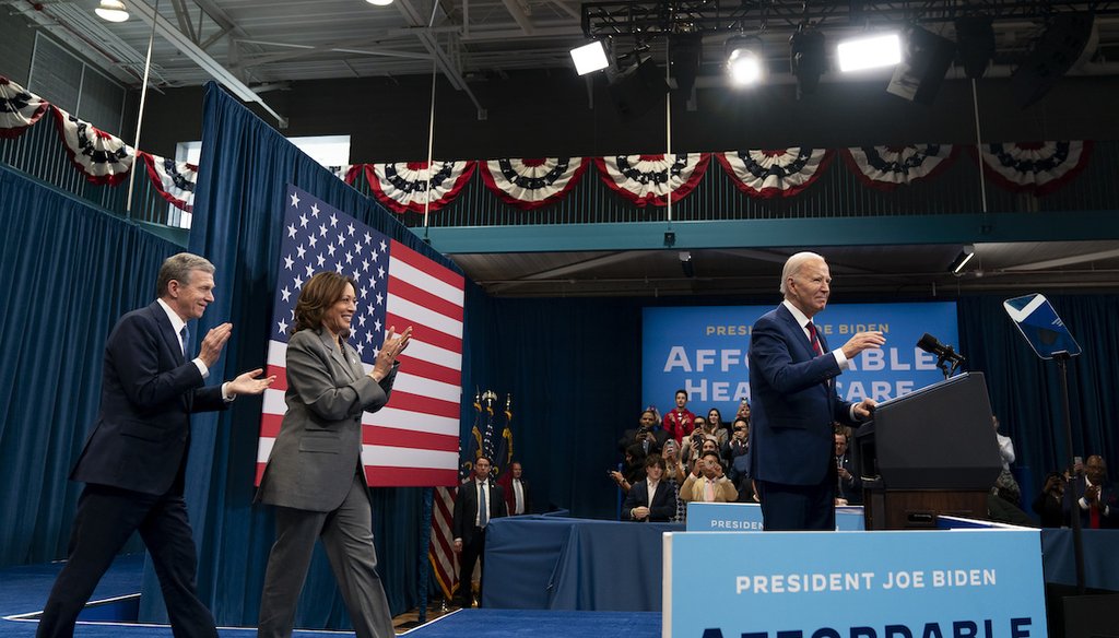 El gobernador demócrata de Carolina del Norte, Roy Cooper, y la vicepresidenta Kamala Harris se acercan al presidente Joe Biden en el podio tras las declaraciones de Biden durante un acto de campaña en Raleigh, NC, el 26 de marzo de 2024. (AP)