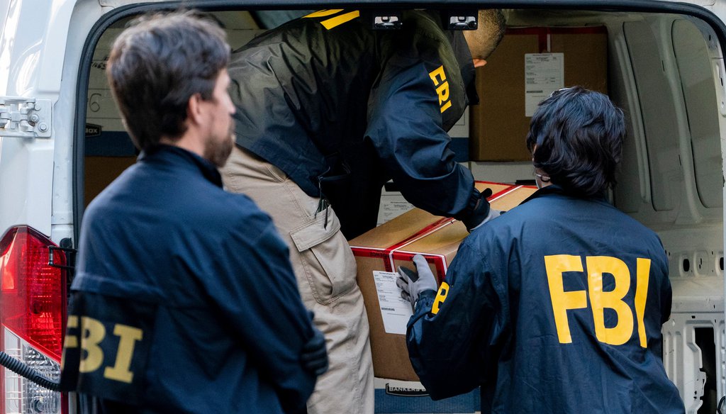 Federal agents load a vehicle with evidence boxes in October 2021. (Associated Press).