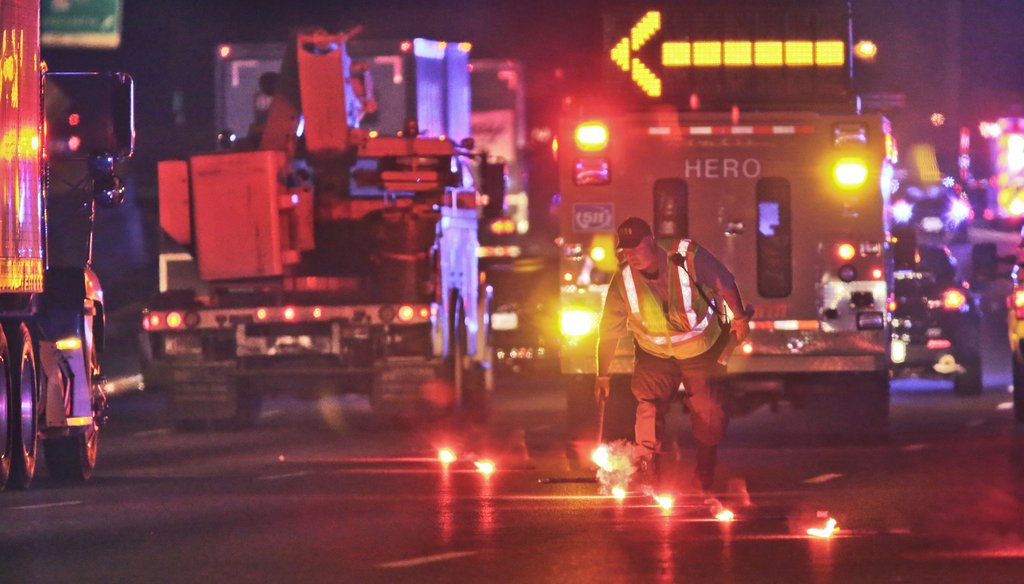 A DOT worker lays down flares at the scene of a fatal traffic crash in 2013 on I-85 in Gwinnett County. Photo by John Spink / AJC 