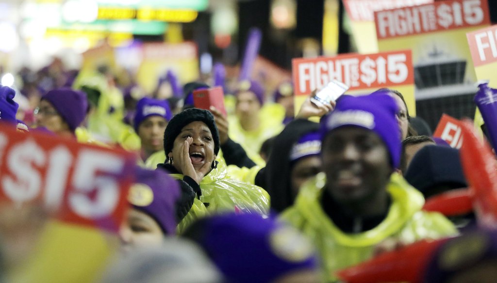 A woman shouts while marching with service workers asking for $15 minimum wage pay during a rally at Newark Liberty International Airport, Tuesday, Nov. 29, 2016, in Newark, N.J. The event was part of the National Day of Action to Fight for $15. (AP)