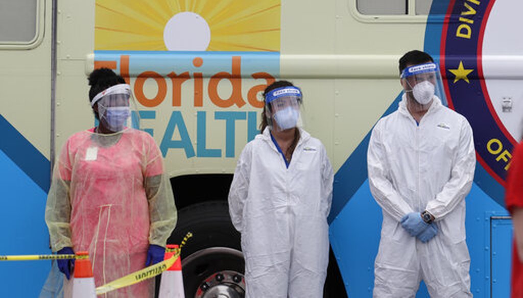 Health care workers wear personal protective equipment as they stand in front of a mobile testing lab during a news conference at a COVID-19 testing site at Hard Rock Stadium, Wednesday, May 6, 2020, in Miami Gardens, Fla. (AP)