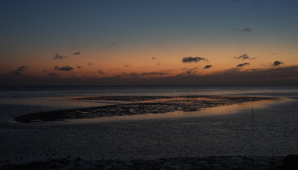 A sunset sky reflects off of water surrounding a sandbar just off the coast of Horseshoe Beach, Fla., Wednesday, May 8, 2024. (AP)
