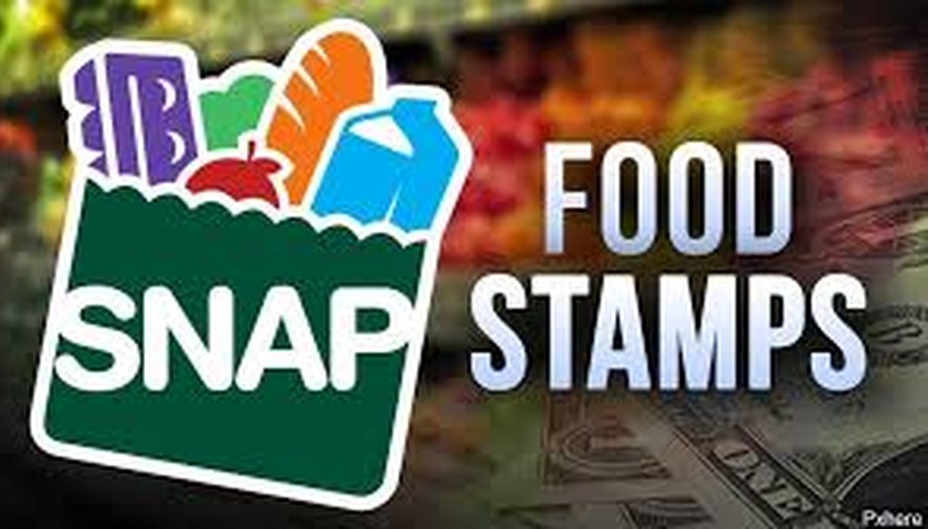 Ashly Bos stretches on her toes to grab a box of instant mashed potatoes while shopping with her mother, Tanya, in Brooksville, Fla. The family of six gets just over $860 per month in food stamps.