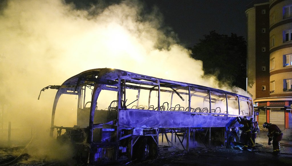 Firefighters use a water hose on a burnt bus in Nanterre, outside Paris, France, on July 1, 2023. Days of rioting followed the fatal police shooting of a teen in Nanterre after he fled a traffic stop. (AP)