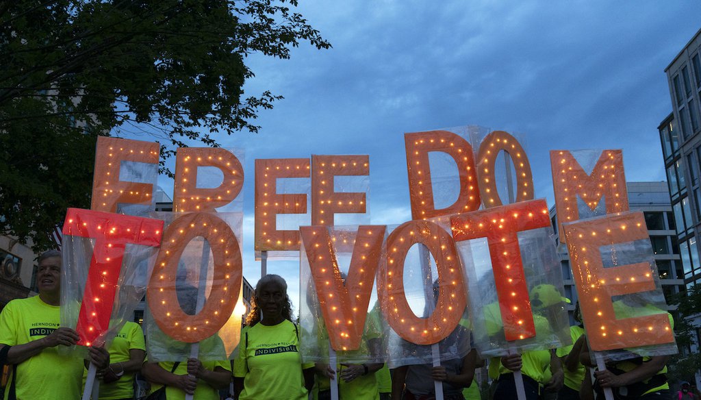 People hold up signs reading "Freedom to vote," during a rally in support of voting rights at Black Lives Matter Plaza in Washington, Saturday, July 17, 2021. (AP)
