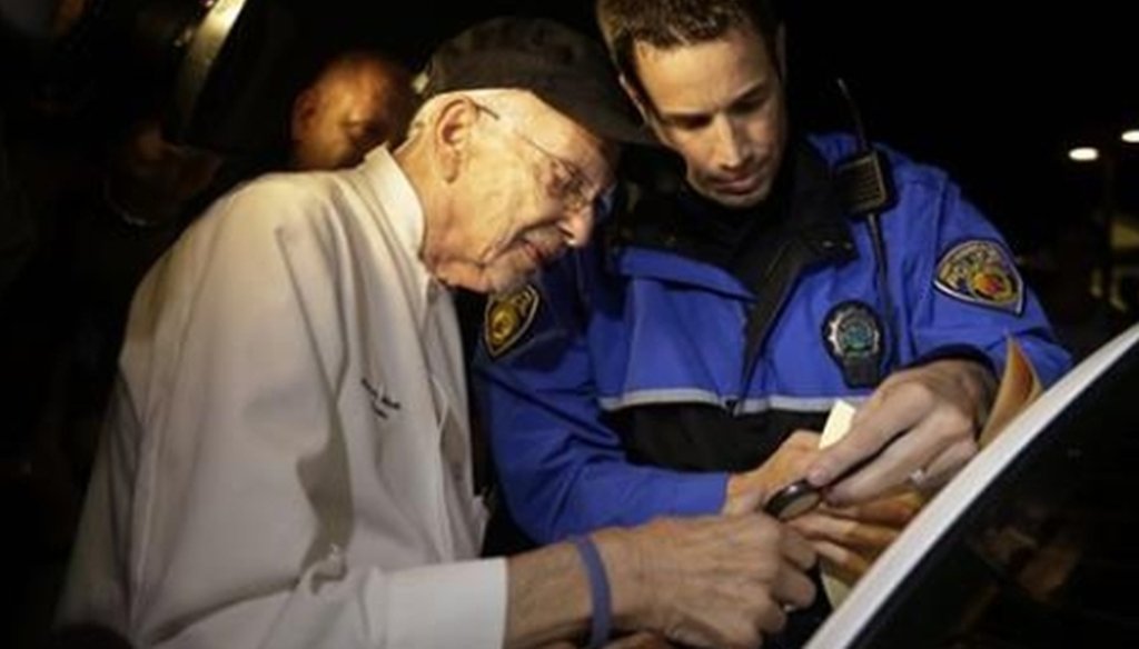 Arnold Abbott, 90, gets fingerprinted by police during his Nov. 5 arrest for violating the city's ordinance about rules for feeding the homeless outdoors. (AP)