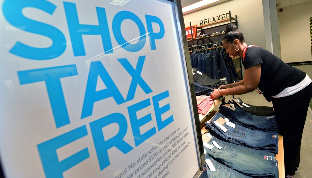 A worker arranges a display of clothing at JC Penney at Northlake Mall before the sales tax holiday in 2013. File photo by Hyosub Shin / AJC
