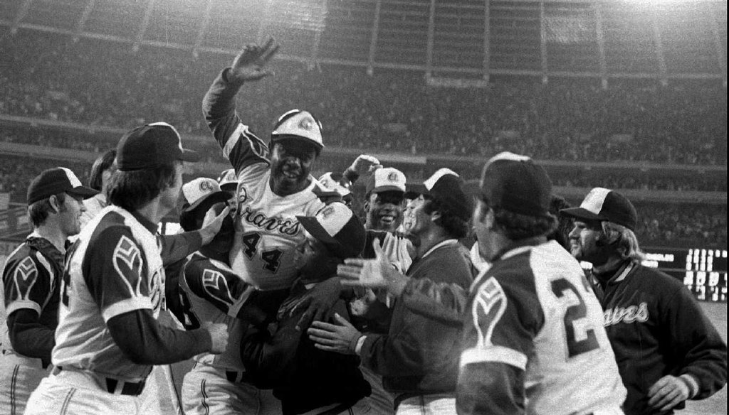 The Atlanta Braves congratulate Hank Aaron, top with hand raised, after his 715th career home run at Atlanta Fulton County Stadium on April 8, 1974. AP file photo.