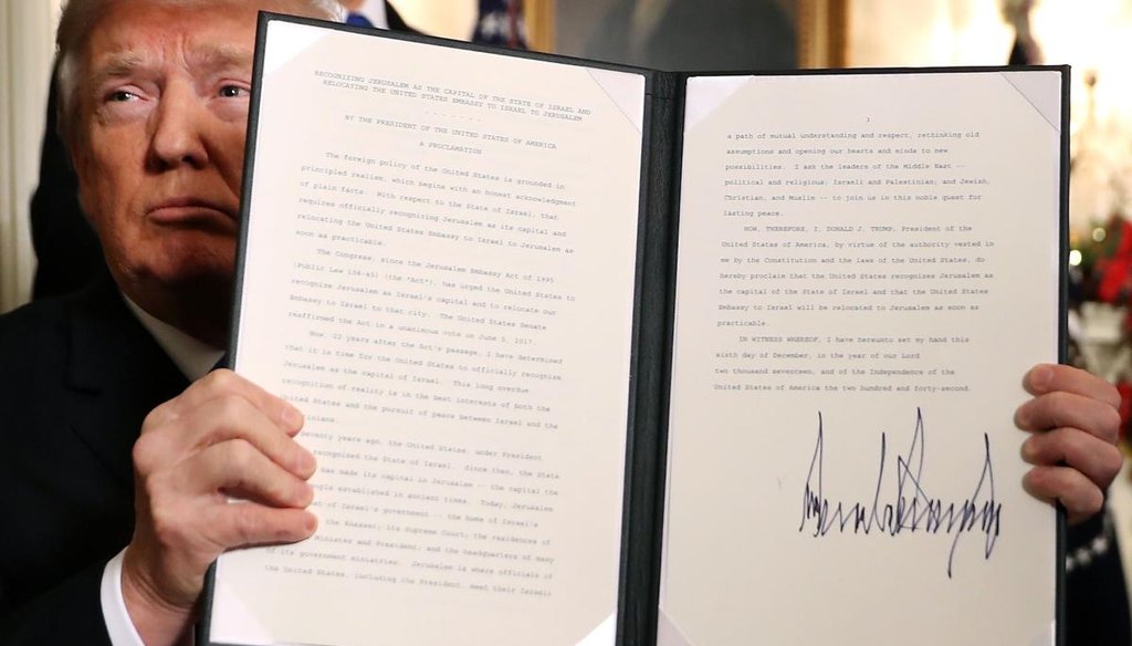 U.S. President Donald Trump holds up a proclamation that the U.S. government will formally recognize Jerusalem as the capital of Israel after signing the document in the Diplomatic Reception Room at the White House on Dec. 6, 2017, in Washington. (Getty)