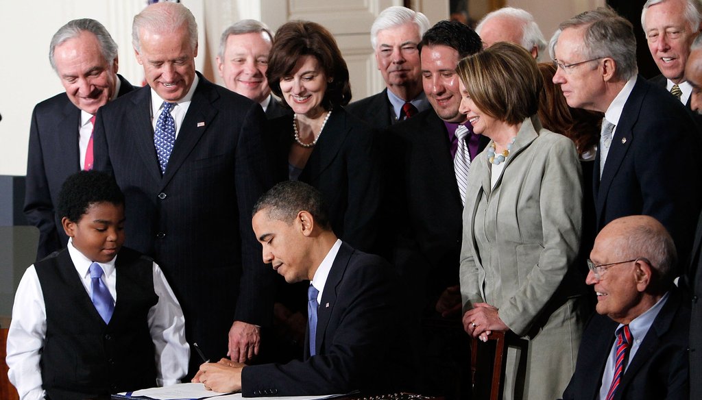 President Barack Obama signs the Affordable Health Care for America Act during a ceremony with fellow Democrats in the East Room of the White House on March 23, 2010, in Washington, D.C. 